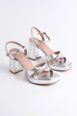 Sandalias negras de cuero sintético con plataforma y tacón cuadrado. Presentan tiras cruzadas en el empeine y pulsera con hebilla al tobillo.