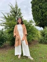 Kimono color camel confeccionado en muselina 100% algodón, con mangas 3/4 y bolsillos frontales.