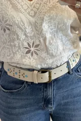 Cinturón marrón de cuero vacuno con hebilla metálica y apliques de tachas y turquesas.