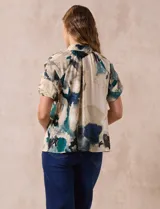 Blusa estampada con cuello fruncido y lazo, mangas cortas con volados.