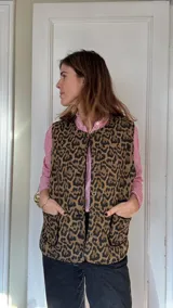 Chaleco reversible con un lado de corderito negro y otro de tussor con estampado animal print.