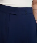 Short pollera de sastreria color azul marino, con pliegues frontales, cierre tradicional y gancho en la cintura. Posee forro interior de malla.