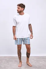 Short de baño celeste con rayas verticales blancas y estampado de flores blancas y azules.