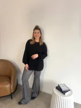 Pantalón palazzo negro con lunares blancos, confeccionado en viscosa.