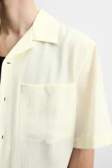 Camisa de hombre relaxed fit con cuello bowling y manga corta, confeccionada en tejido fluido con mezcla de viscosa a rayas verticales en tonos verde y blanco.