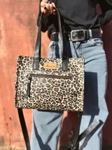 Cartera bandolera Shill Mini de cuero con estampado animal print, forro de tela y correa larga negra regulable. Cuenta con bolsillo frontal con cierre y bolsillo interno. Fabricación nacional.