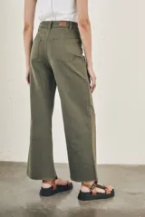 Pantalón wide leg color beige, de tiro alto, ligeramente ajustado en cintura y con ruedo desflecado.