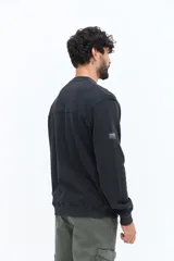 Buzo de algodón color negro lavado, con cuello redondo y estampado frontal en blanco con texto que incluye "BROOKSFIELD COVENT GARDEN LON UK". Presenta un pequeño parche negro en la manga izquierda.