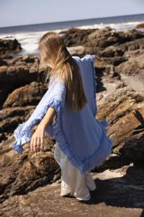 Ruana marrón tejida en lana merino con detalles de lino y flecos.