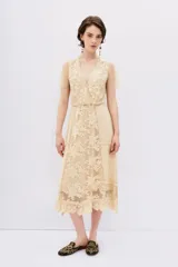 Vestido color crema con encaje floral, escote en V y mangas cortas de tul con lunares.