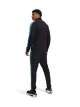 Conjunto deportivo Under Armour gris con detalles en negro. Incluye campera con cierre y pantalón con cintura elástica y cordón ajustable. Ambos con logo de la marca en el pecho y en la pierna.