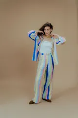 Camisa de mangas largas con puños elásticos y cuello clásico. Presenta un estampado a rayas verticales de colores pastel y cierre frontal con botones.