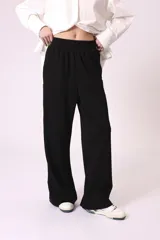 Pantalón de vestir color beige, de corte palazzo y tiro alto, con cierre lateral con botón y cremallera.