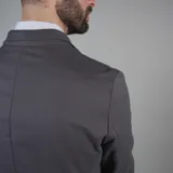 Saco color beige de gabardina, con solapas de muesca, cierre de dos botones, tres bolsillos externos y un bolsillo interno.