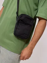 Bandolera negra de poliéster con correa ajustable y logo estampado.