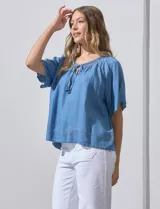 Blusa celeste de lyocell con escote en V, punto smock y lazo de ajuste.