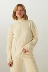 Sweater de lana color crudo, tejido de punto industrial con cuello medio.