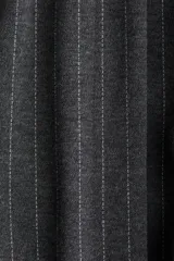 Chaleco gris oscuro con finas rayas verticales blancas, cuello redondo y sin mangas. Incluye cinturón de la misma tela para atar en la cintura.