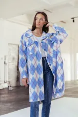 Camisa larga con estampado de rombos en tonos celeste, blanco y rosa. Tiene cuello camisero, cierre con botones y bolsillos frontales.