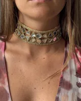 Gargantilla dorada con espejos triangulares y detalles de cadena.