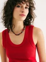 Musculosa negra de tela acanalada, con escote redondo pronunciado (cuello U) y corte ajustado al cuerpo.