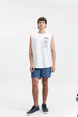 Musculosa blanca de algodón con corte oversize y estampado en la espalda con imagen de playa, texto y código de barras.