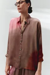 Camisa oversize color marrón con degradé rosado, cuello clásico, botones al frente, mangas largas con puños abotonados, canesú con frunces en la espalda y aberturas laterales.