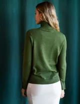 Polera de punto fino marca Nienty, color blanco, con cuello alto volcado y mangas largas con detalle de tajo en los puños.