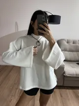 Sweater blanco de tela Aspen, cuello alto y mangas largas con puños acampanados.