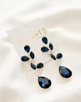 Aros colgantes plateados con forma de hojas y lágrimas, con incrustaciones de strass blancos y piedras acrílicas facetadas color azul marino.