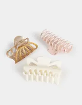 Set de tres broches para el pelo en diferentes formas y colores: uno dorado con efecto marmolado, uno blanco y uno rosa con estampado floral.