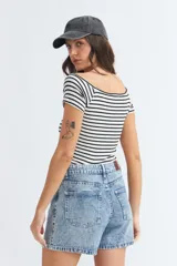 Remera fucsia de algodón con elastano, corte ajustado, escote off-shoulder y mangas cortas.