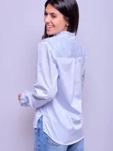 Camisa celeste de algodón con cuello mao y volados en el frente.