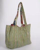 Tote bag reversible con diseño colorido y patrones florales en varios tonos.