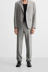 Pantalón de vestir gris claro con textura, corte regular fit, bolsillos laterales y traseros de doble vivo con botón. Cierre frontal con cremallera y botón.