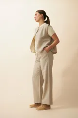 Chaleco marrón con solapas amplias y terminaciones envivadas. Diseño reversible y sin mangas.