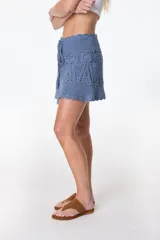 Minifalda tejida a crochet color ladrillo, con cintura alta y cordón trenzado con borlas.