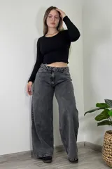 Pantalón jean gris oscuro de tiro medio, corte amplio y estilo baggy.