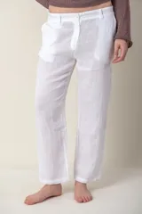 Pantalón de lino blanco, de corte recto y tiro medio, con bolsillos laterales y cierre frontal con botón y cremallera.