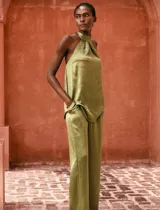 Conjunto verde oliva de blusa con cuello halter y espalda descubierta, y pantalón de corte recto con cintura elástica.