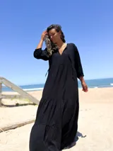 Vestido largo negro con escote en V y mangas 3/4 amplias.