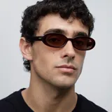 Lentes de sol ovalados color marrón, con montura de acetato color borgoña.