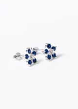 Par de aros de plata 925 con forma de flor, con cinco pétalos de zirconias azules y centro de zirconias blancas. Cierre a presión.