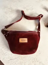 Riñonera de cuero color borgoña con correa ajustable.