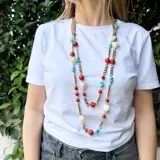 Collar largo de cadena de bronce con cuentas de coral, turquesa y nácar.