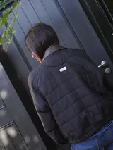 Campera puffer azul marino con diseño acolchado de rombos, cuello de cuero sintético negro, mangas largas abullonadas con puños elásticos y cierre frontal con cremallera.