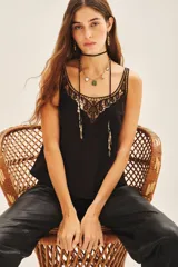 Top tipo musculosa confeccionado en modal satén, color negro, con terminación de calado en el escote delantero y en la espalda, acompañado de bordados a tono.
