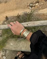 Brazalete ancho de bronce macizo con textura irregular.