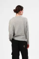 Sweater gris de cashmere y lana con estampado floral en negro y beige en los hombros.
