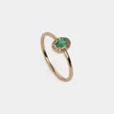 Anillo de oro amarillo 18k con esmeralda ovalada y pequeños brillantes alrededor.